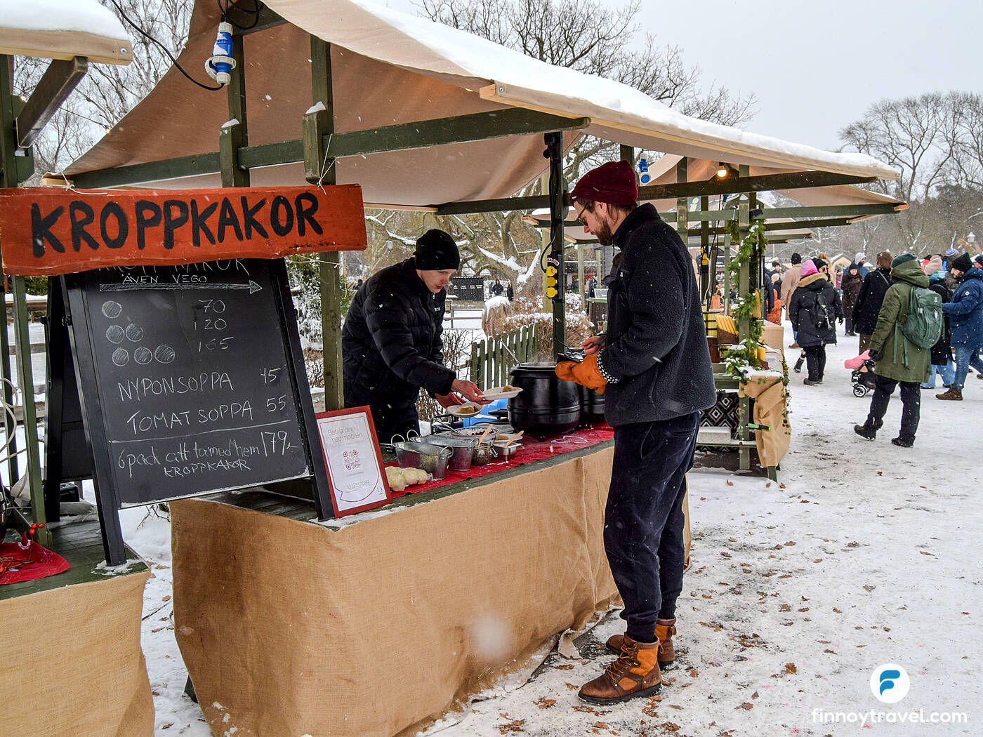 A visitor is buying soup from a market stall at the Skansen