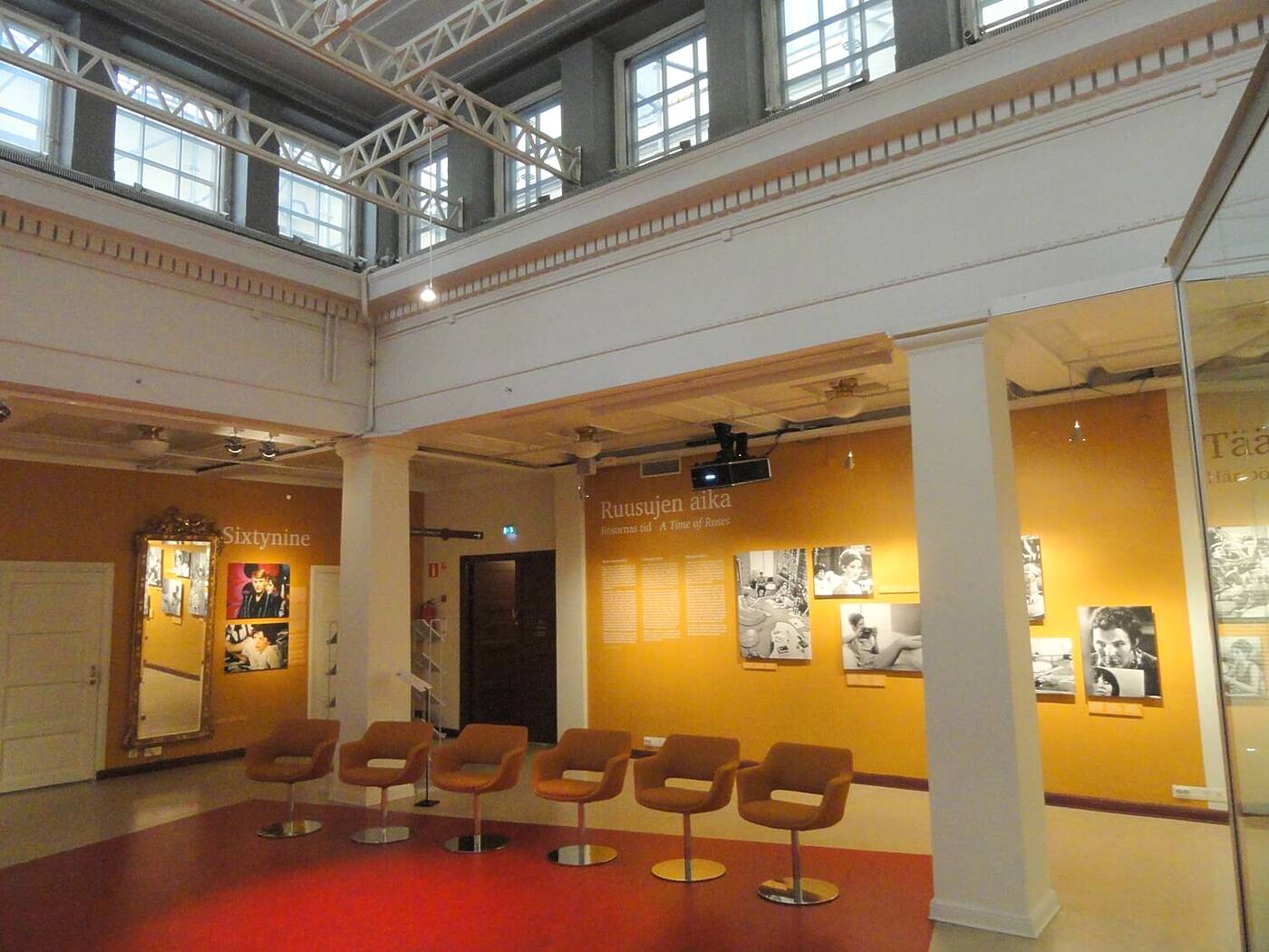 高い天井と鉄骨梁、歴史的建物に現代的な展示が並ぶヘルシンキ市立博物館の展示空間。