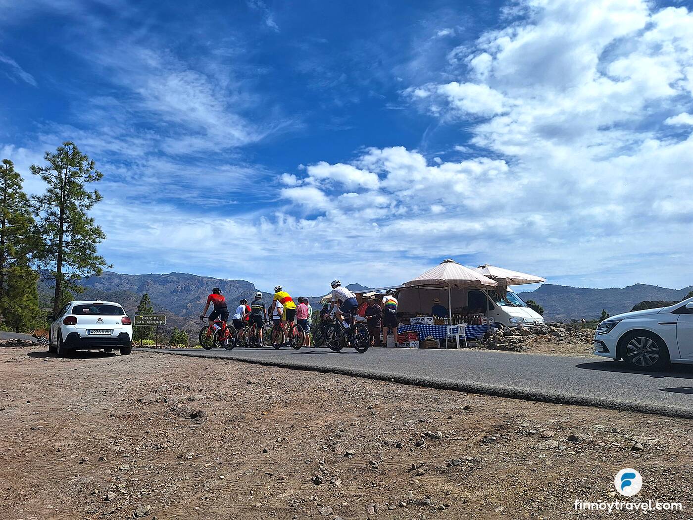 Ciclista e uma banca de vendas nas montanhas