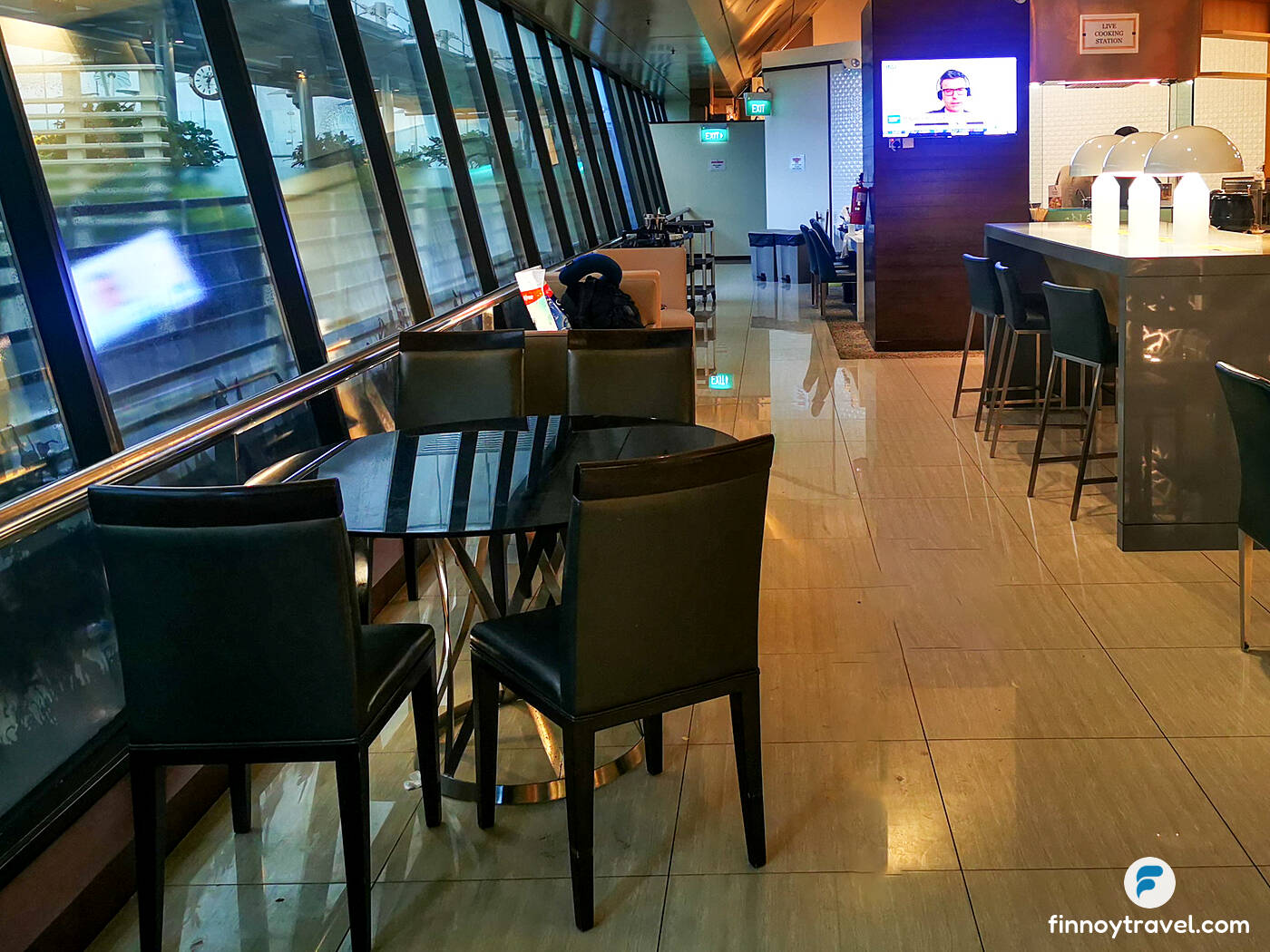 &aacute;rea de assentos na Ambassador Transit Lounge, perto da mesa de buffet.