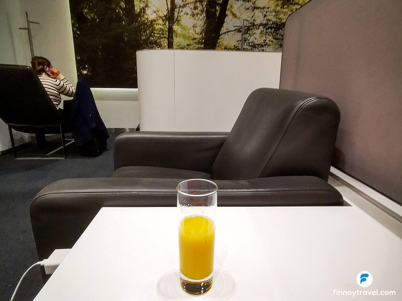 Um copo de suco de laranja no Lufthansa Business Lounge do Port&atilde;o K11, em Munique