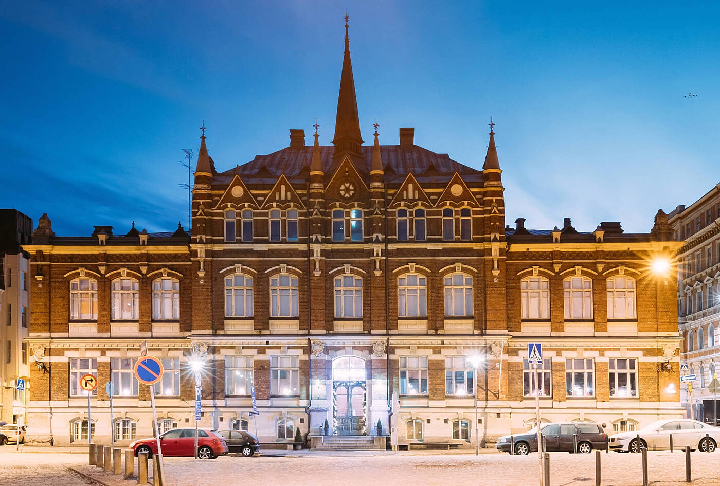 Design Museum Helsinki sa dapithapon na may neo-Gothic na fasadang laryo, matarik na bubong, at simetrikong mga bintana.