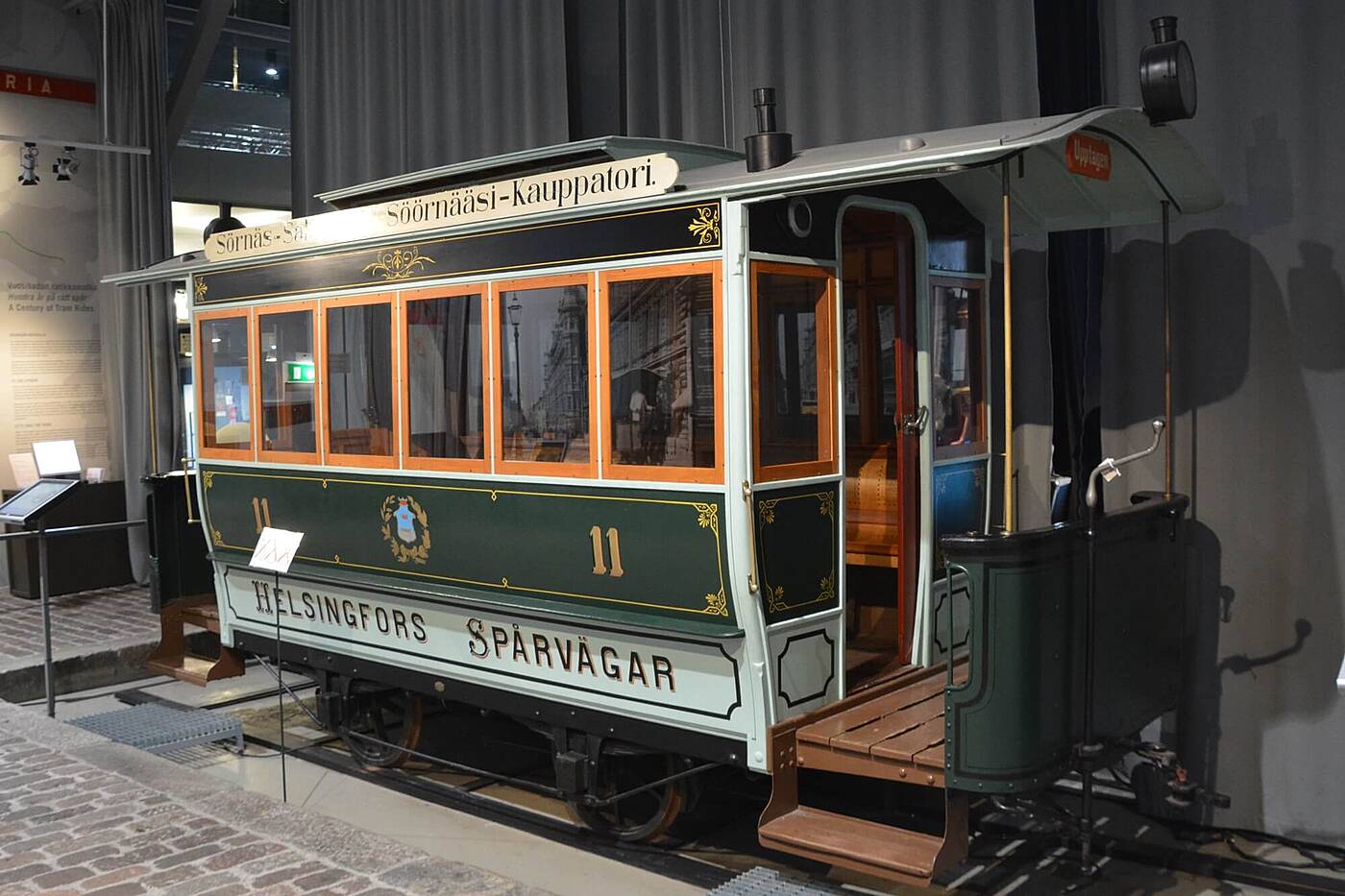 Makina ng lumang tram sa Tram Museum Helsinki na may kahoy na panel, lumang karatula, at orihinal na interior.