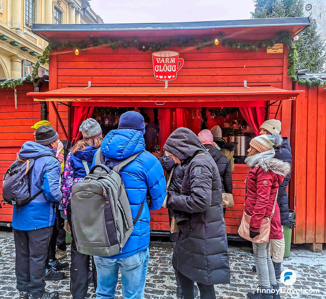 在 Stortorget 圣诞市集排队领取热红酒（Gl&ouml;gg）的游客